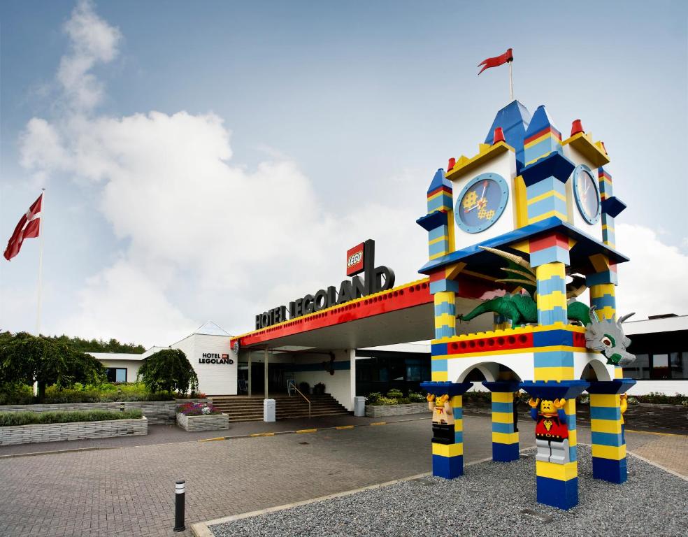 uma torre de relógio colorida em frente a um edifício em Hotel Legoland em Billund