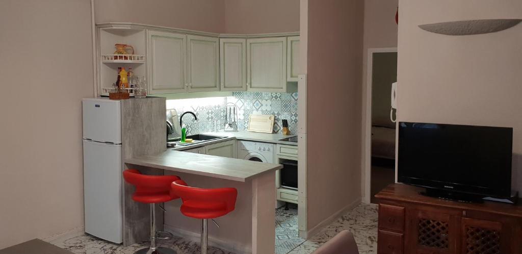 a kitchen with a white refrigerator and red stools at Au Coeur du vieux Nice in Nice