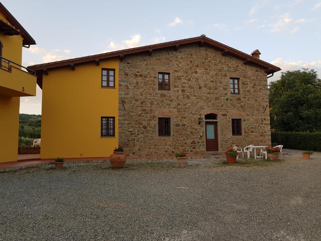 ein großes Steinhaus mit einem gelben in der Unterkunft Agriturismo Podere Casalone in Limite