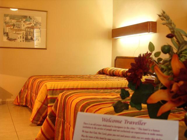 una habitación de hotel con 2 camas y un cartel en una habitación en Hotel El Dorado, en Sabinas