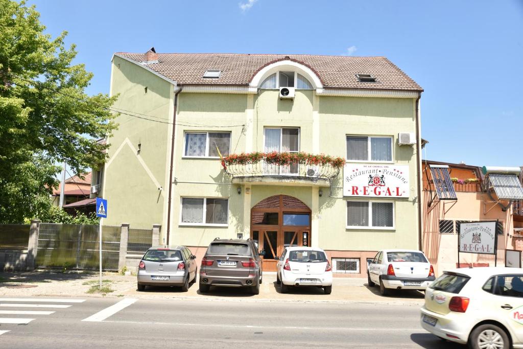 a building with cars parked in front of it at Pension Regal in Satu Mare