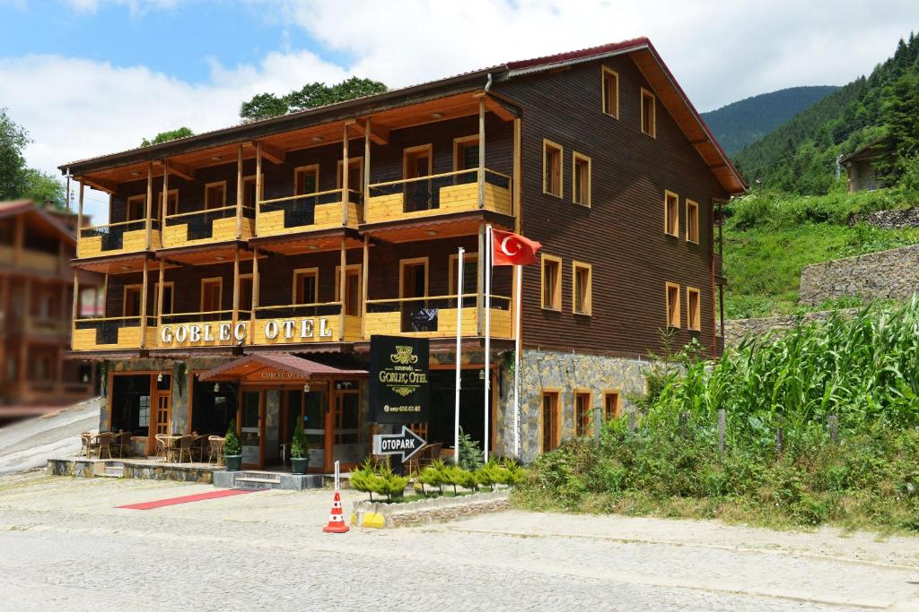 un gran edificio de madera al lado de una calle en Goblec Hotel & Bungalow, en Uzungöl