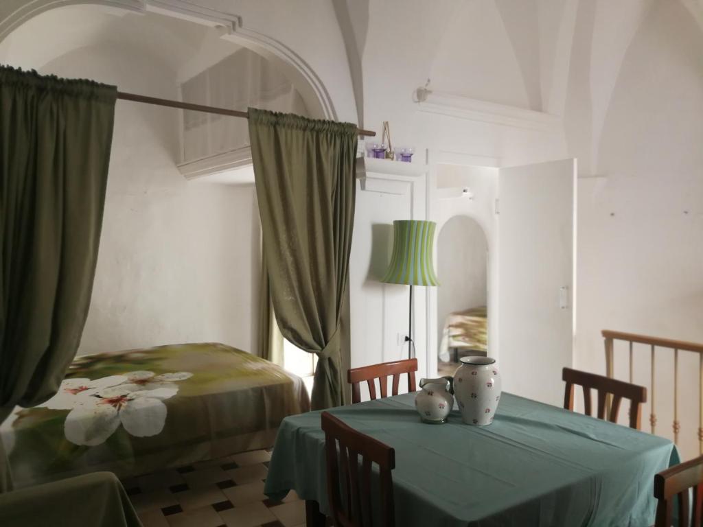 Habitación con 2 camas, mesa y lámpara. en Casa La Chicca di Gina, en Ostuni