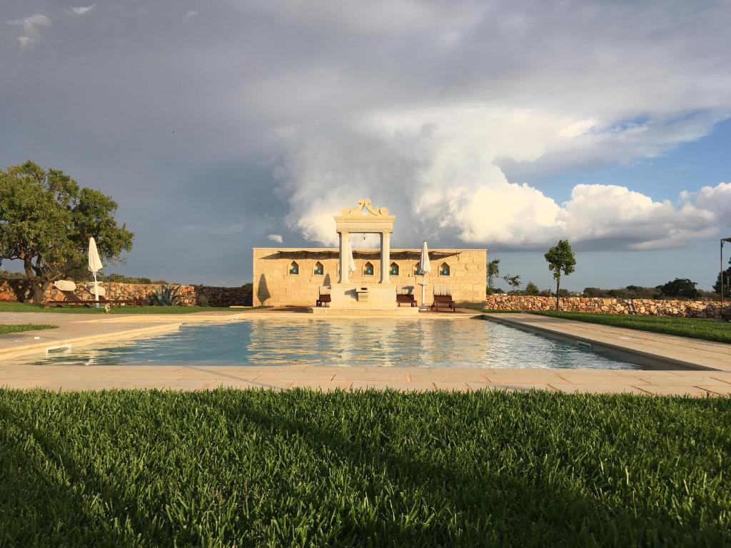 a building with a pool of water in front of it at Masseria Cisternella in Alliste