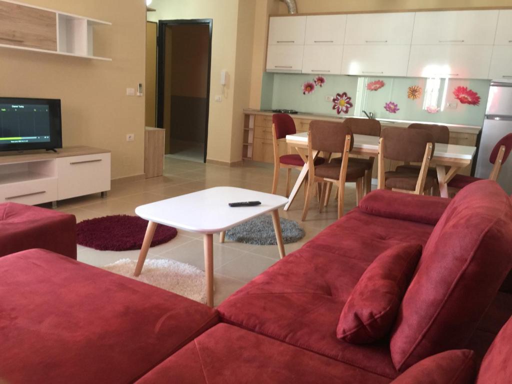 a living room with a red couch and a table at Premium Apartaments 02-03 in Vlorë