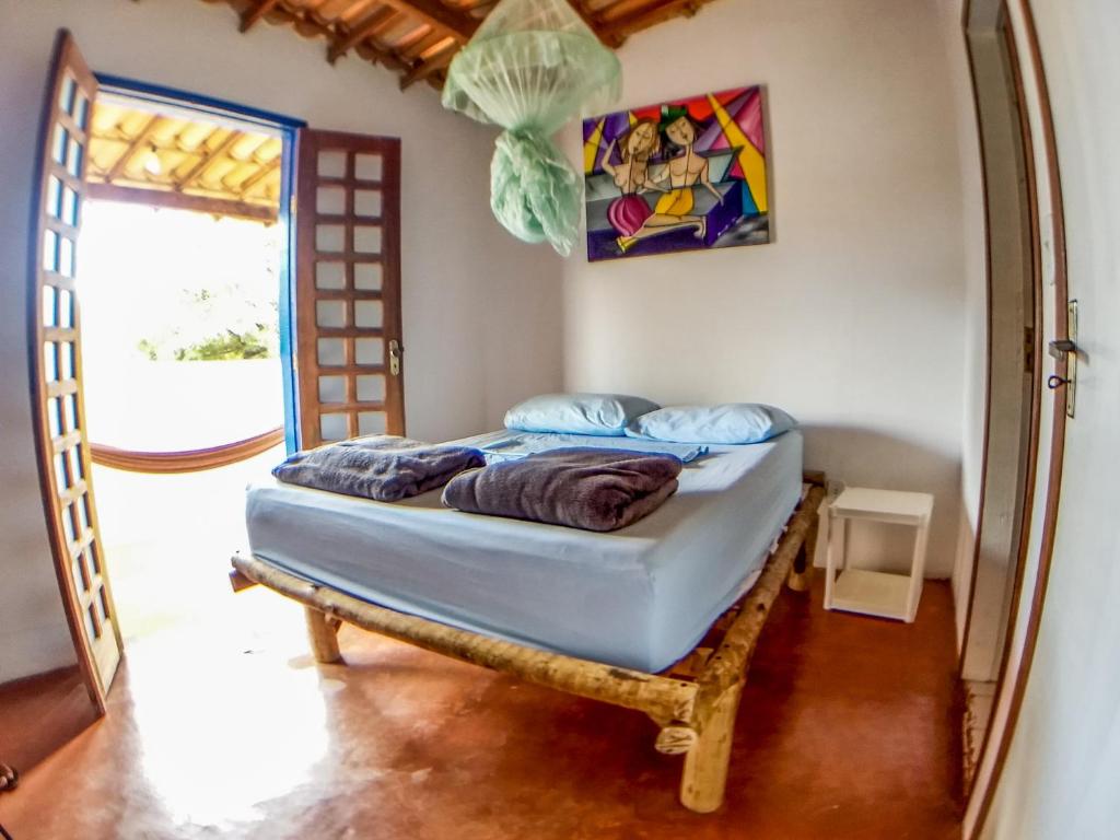 a bedroom with a bed in a room with a window at Hospeda Vila in Vale do Capao