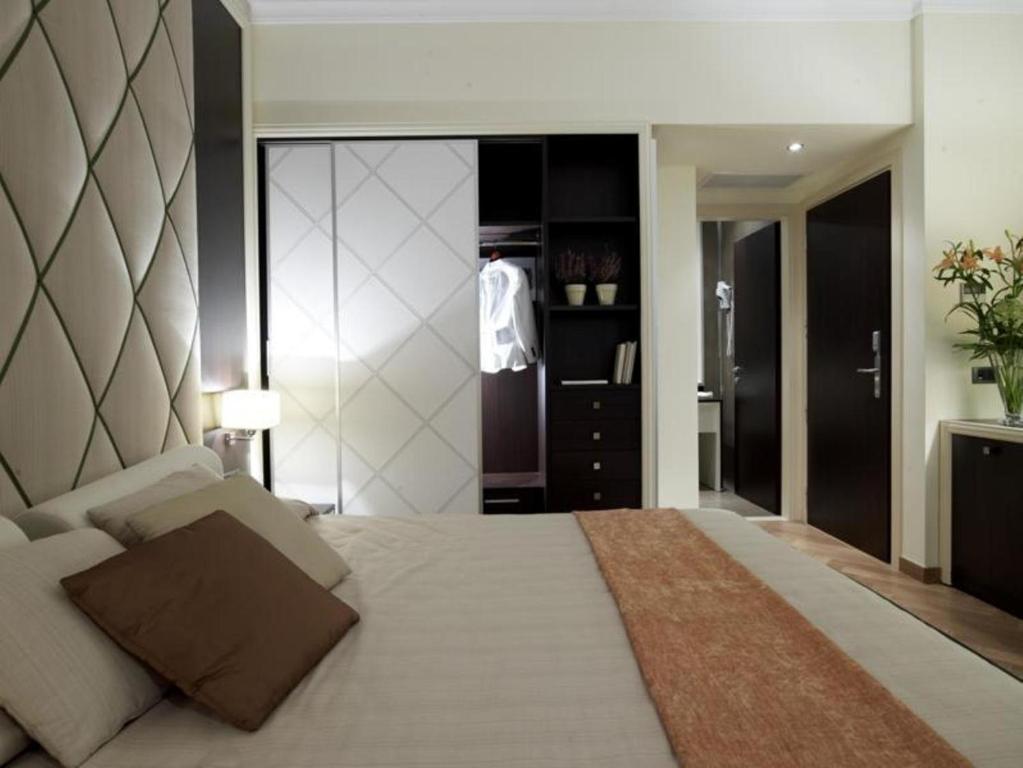 - une chambre avec un grand lit et un placard dans l'établissement Menelaion Hotel, à Sparte