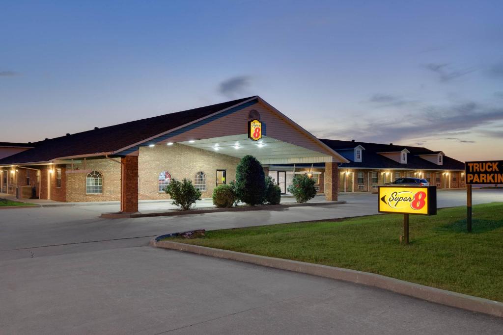 a building with a sign in front of it at Super 8 by Wyndham Big Cabin/Vinita Area in Vinita