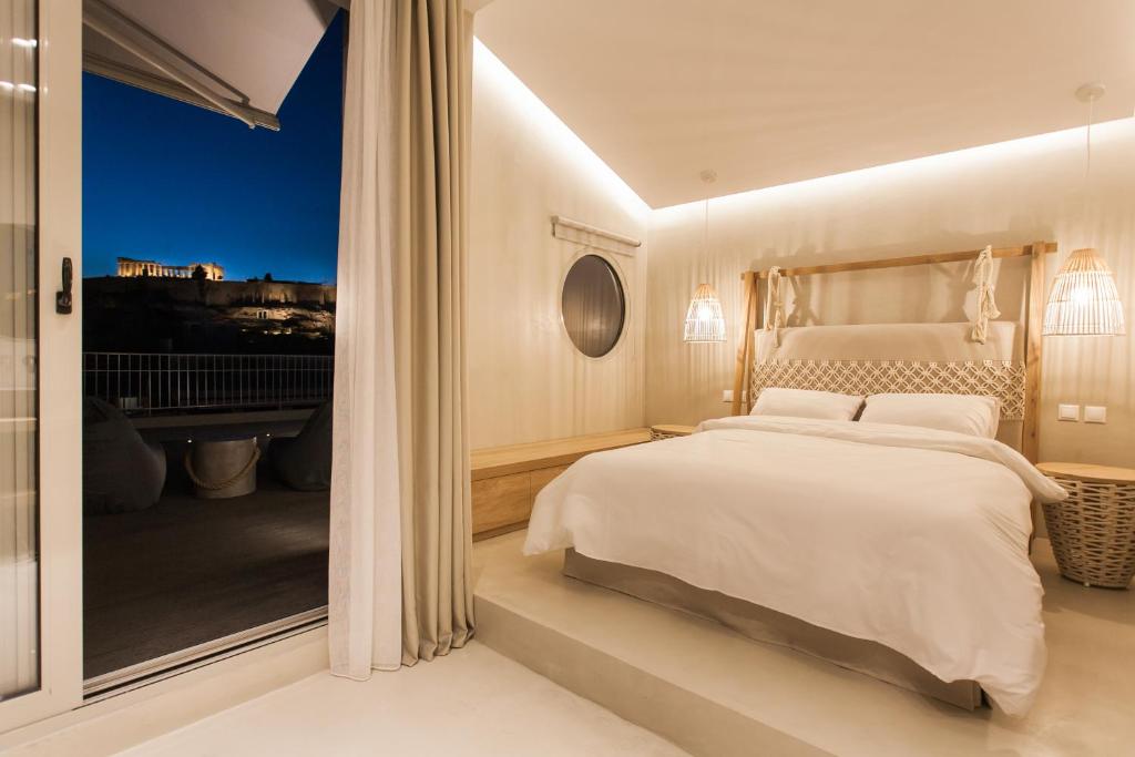 - une chambre blanche avec un grand lit et une fenêtre dans l'établissement Acropolis 360° sky suite, à Athènes
