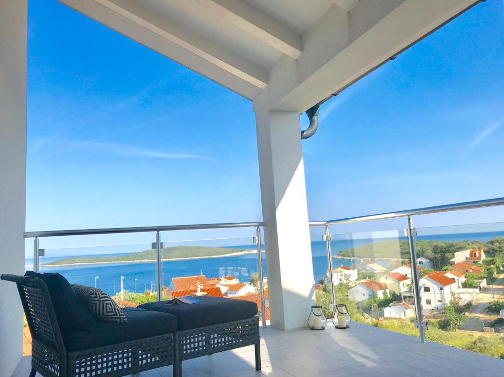 a balcony with a couch and a view of the ocean at VisitAylinVis in Vis