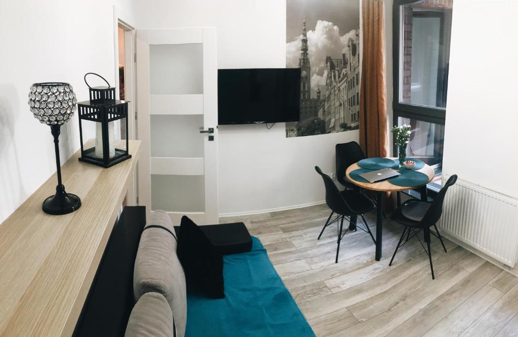Brovar City Centre Apartament في غدانسك: غرفة معيشة مع أريكة وطاولة