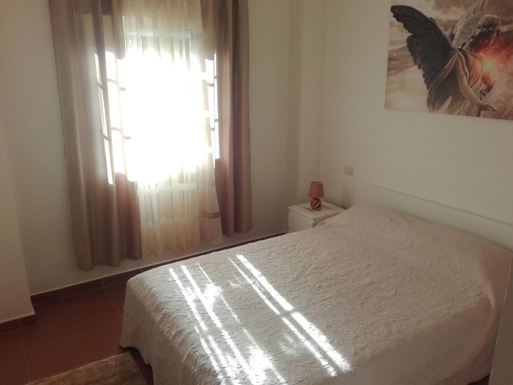1 dormitorio con cama blanca y ventana en Costa Esuri, Albatros Golf 1 Ayamonte, en Ayamonte