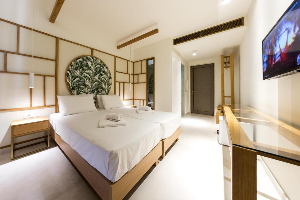 a bedroom with a large bed and a tv at Agave Boutique Hotel in Laganas