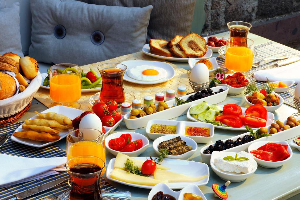 einen Tisch voller Frühstückslebensmittel und Getränke in der Unterkunft YundAntik Cunda Konaklari in Ayvalık