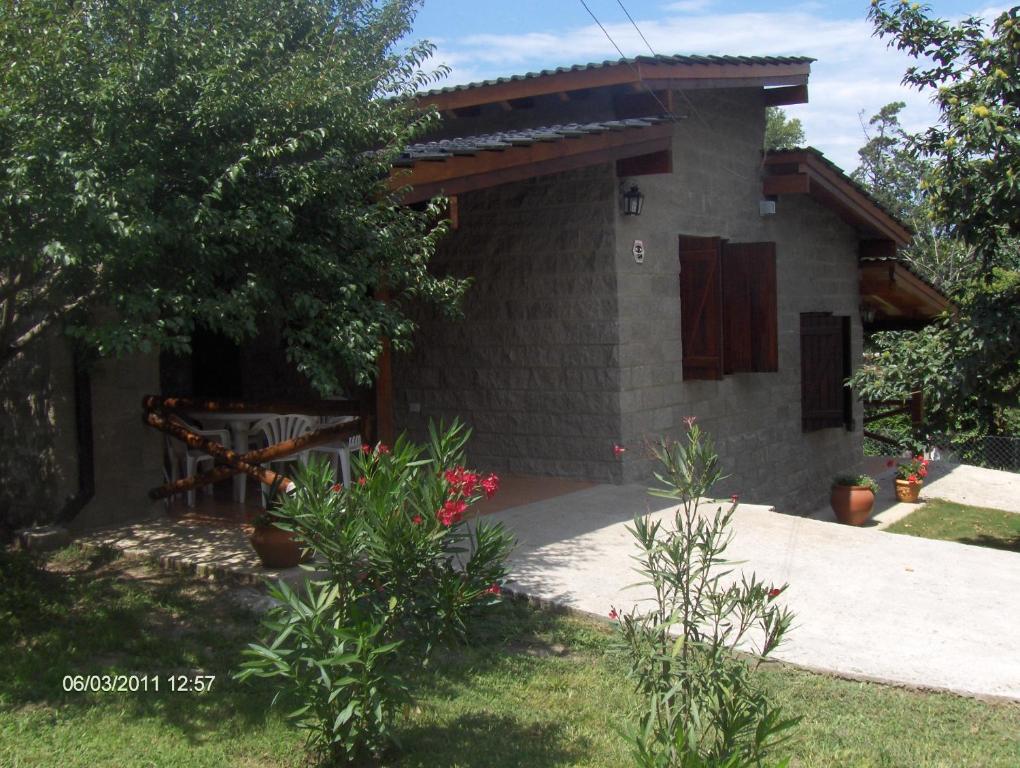 une petite maison en pierre avec un chemin menant à elle dans l'établissement Cabanas los lirios, à Santa Rosa de Calamuchita