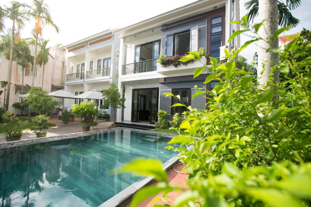 a swimming pool in front of a building at Yen villa Hội An in Hoi An