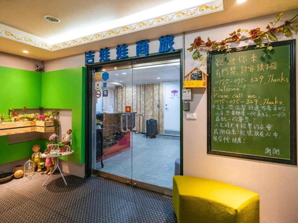 a restaurant with a green wall and a chalkboard on the wall at Gwawa Hotel in Kaohsiung