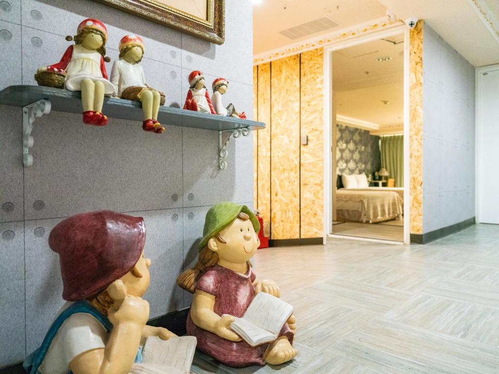 a room with figurines of children sitting on a shelf at Gwawa Hotel in Kaohsiung