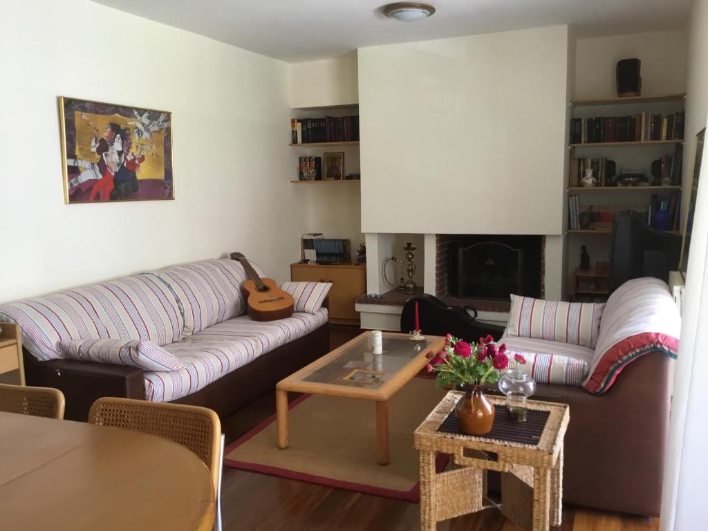 a living room with a couch and a table at AGIA PARASKEVI appartement près du métro in Athens