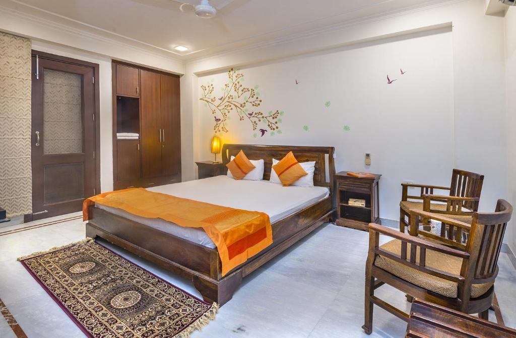 um quarto com uma cama e uma cadeira em Tree of Life Bed & Breakfast em Nova Deli
