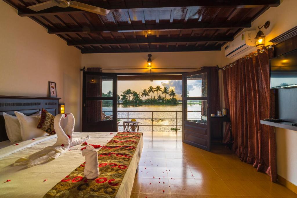 a bedroom with a bed with a view of the ocean at Warmth Lake Haven in Alleppey