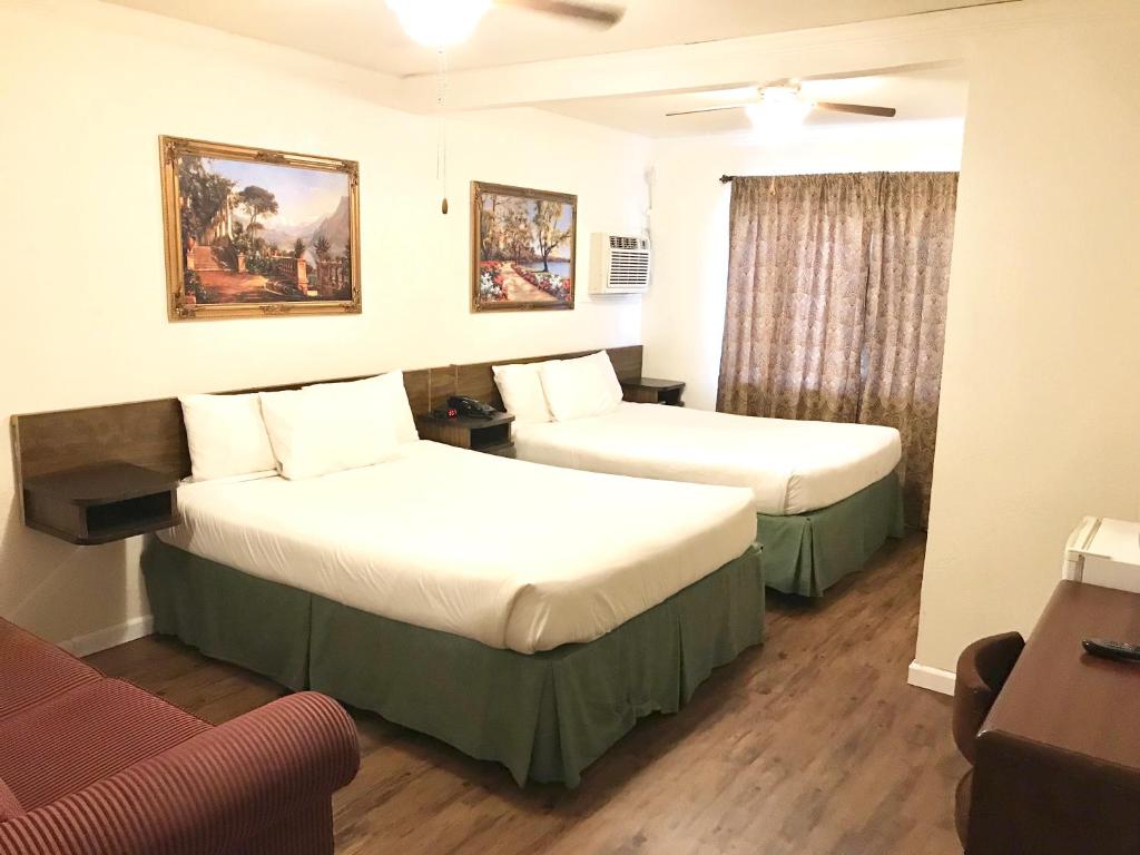 a hotel room with two beds and a couch at El Dorado Motel in Twain Harte