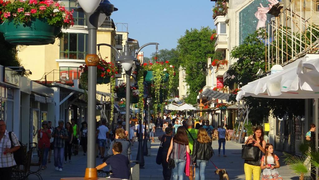 Eine Menschenmenge, die eine belebte Stadtstraße entlangläuft in der Unterkunft Apartament Bogoridi in Burgas City