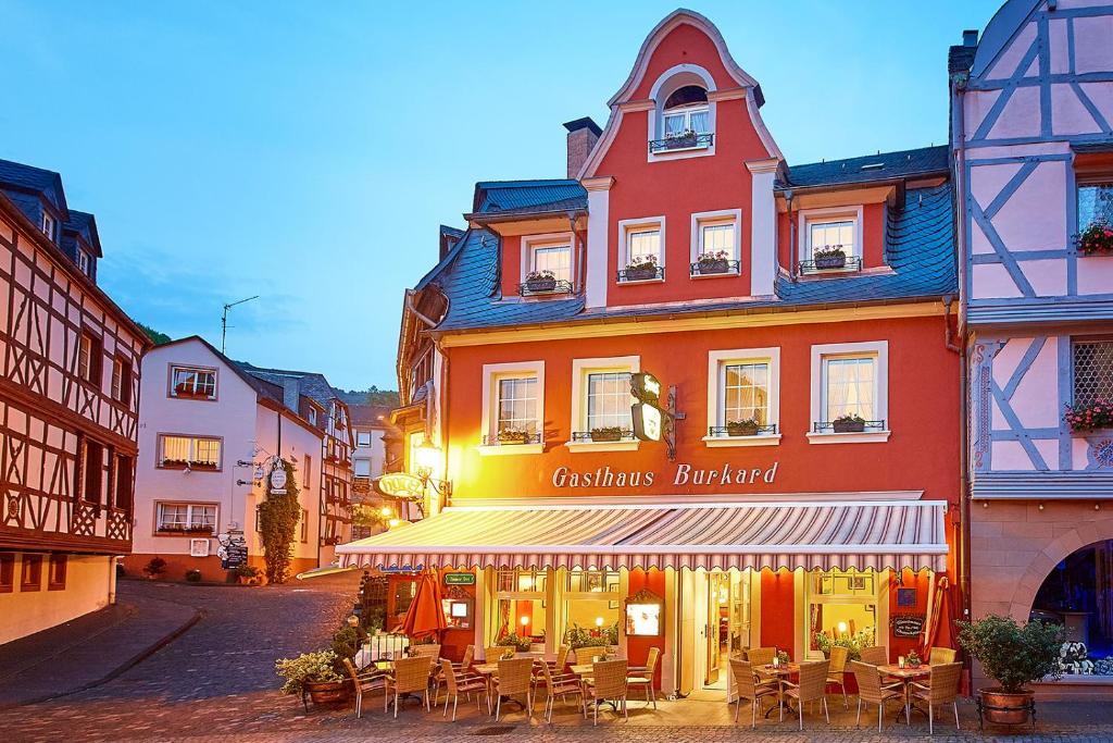 ein Gebäude mit Tischen und Stühlen in einer Straße in der Unterkunft Gast-und Weinhaus Burkard in Bernkastel-Kues