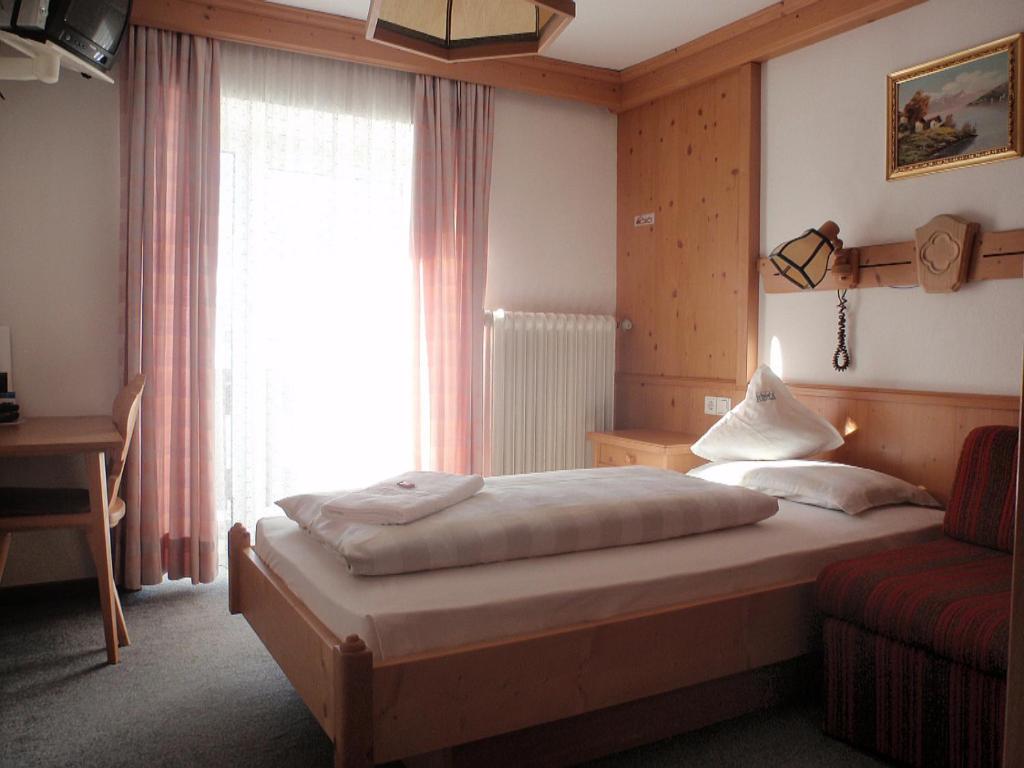 a hotel room with a bed and a window at Hotel Rezia in La Villa