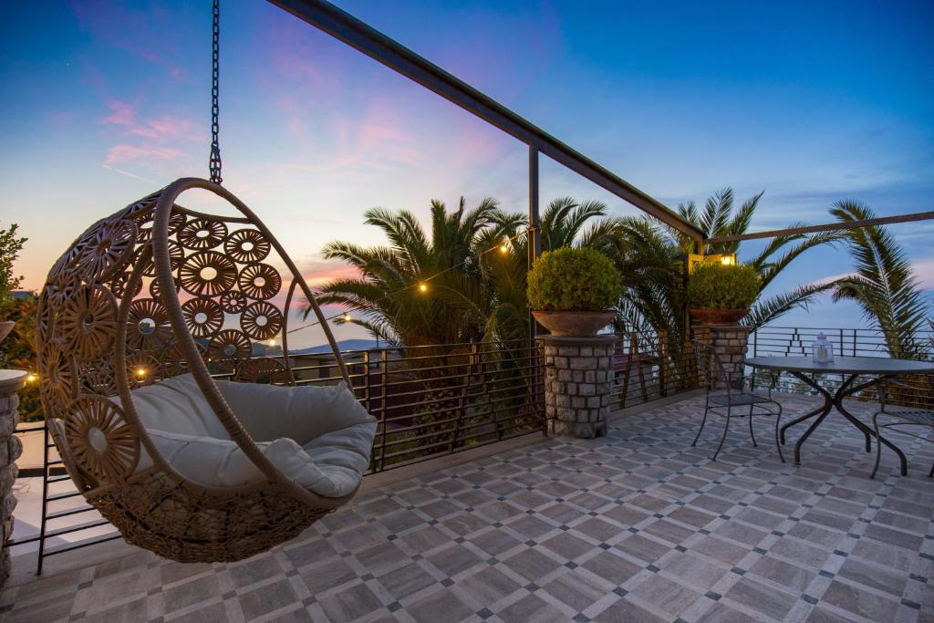 a swing on the balcony of a house with a table at Romantic Relais Sorrento in Sorrento