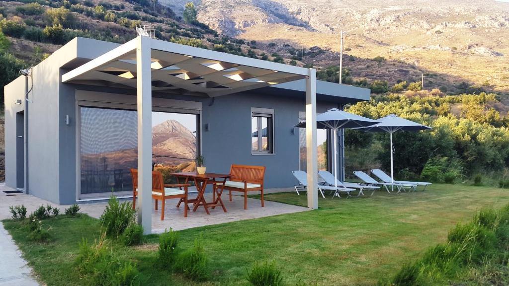 Casa con patio con mesa y sillas en Villa Aias en Plakias