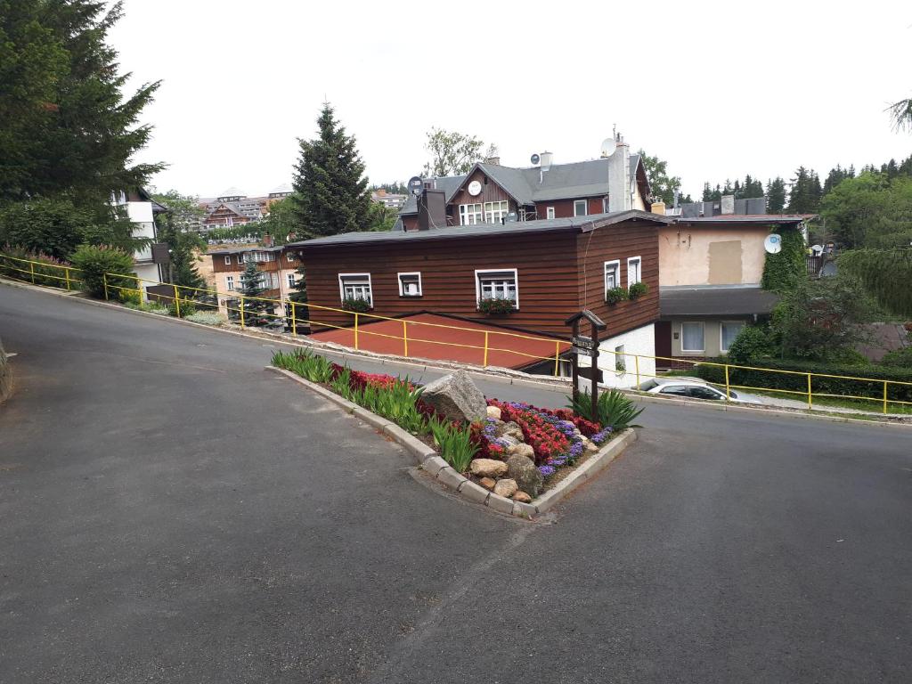 uma rua com uma casa e flores no lado da estrada em Apartament Beata em Karpacz