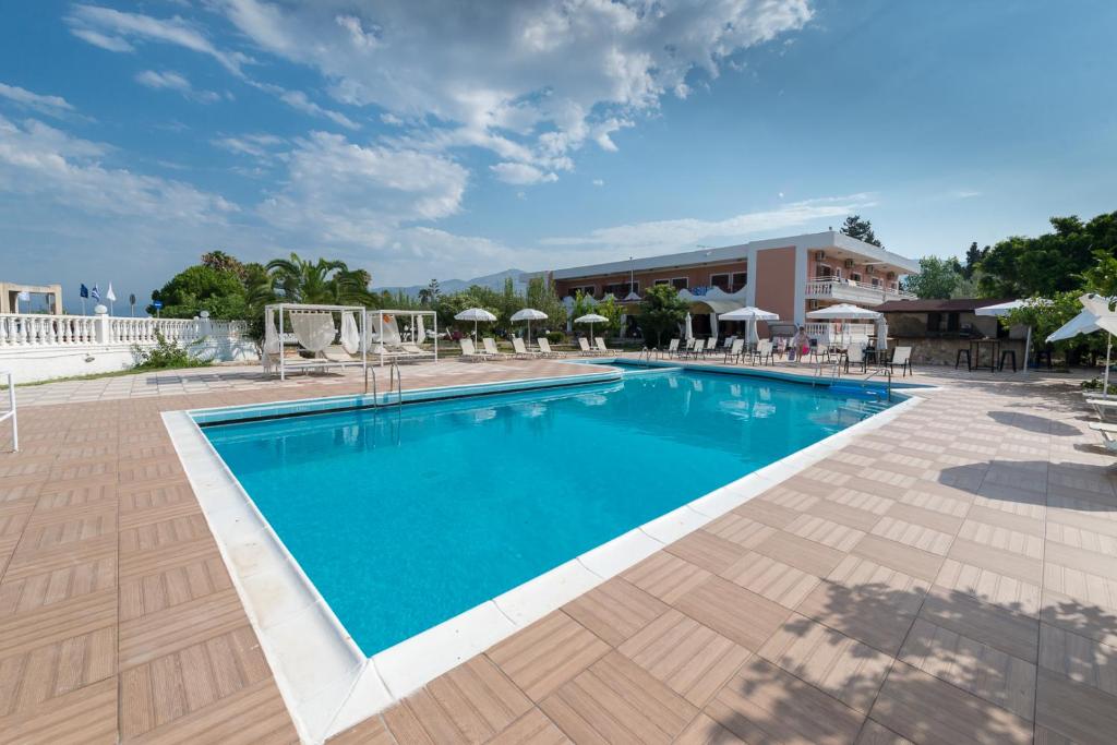 una piscina en un complejo con sillas y sombrillas en Galaxy Hotel, en Argostoli