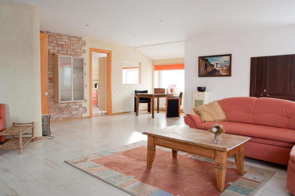 a living room with a red couch and a table at Old Town Apartments in Alytus