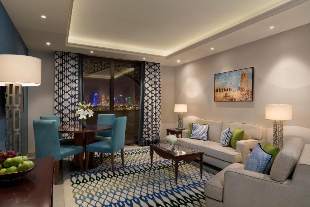 uma sala de estar com um sofá e uma mesa em Al Najada Doha Hotel Apartments by Oaks em Doha