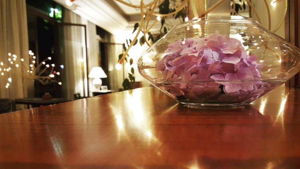 een glazen vaas gevuld met roze bloemen op een tafel bij Hotel Delle Ortensie in Fiuggi