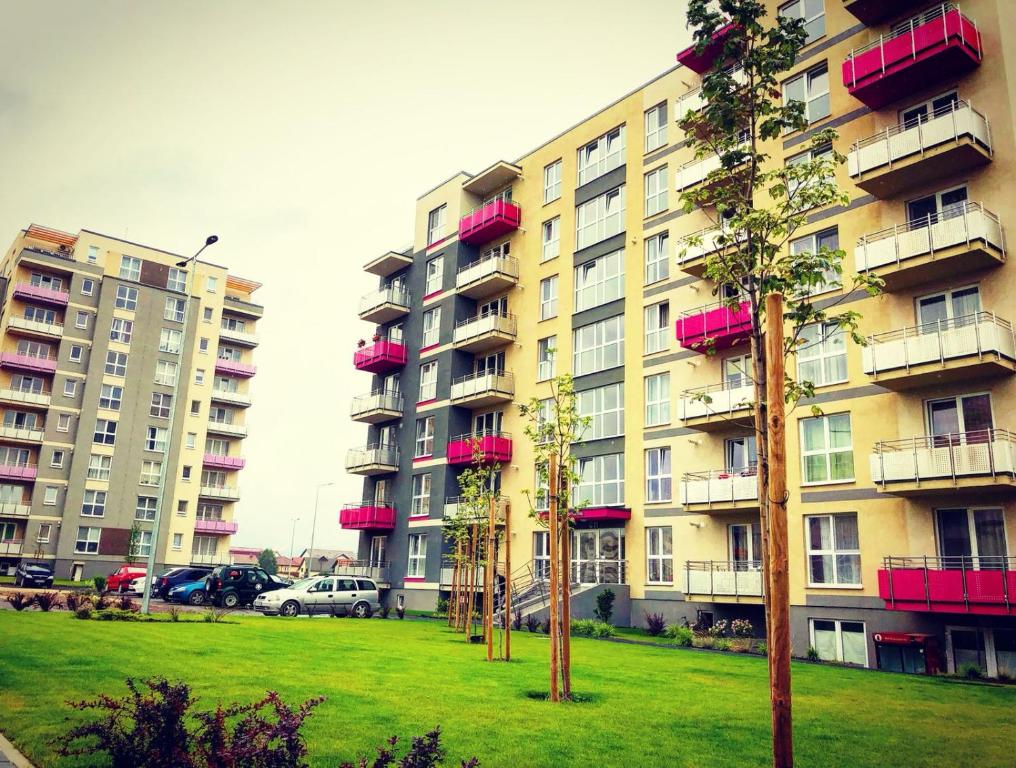 Dos edificios altos con balcones rojos en un parque en Avantgarden Apart, en Brasov