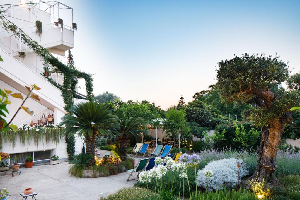 a garden with chairs and plants and a building at Reggin&egrave; Holiday Apartments in Sant'Agnello