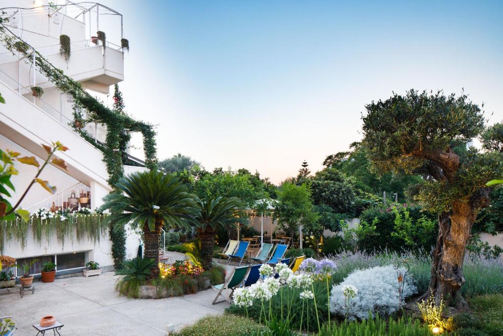 un giardino con sedie e piante e un edificio di Regginè Holiday Apartments a Sant'Agnello