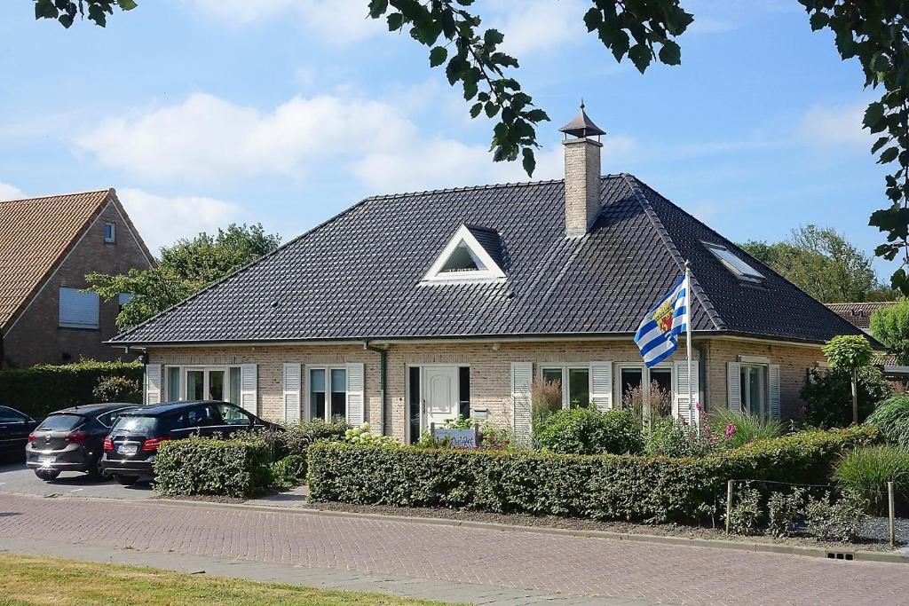 uma casa com um telhado com um triângulo em B&B Witvliet, kamers en studio met heerlijk ontbijt ! em Zoutelande