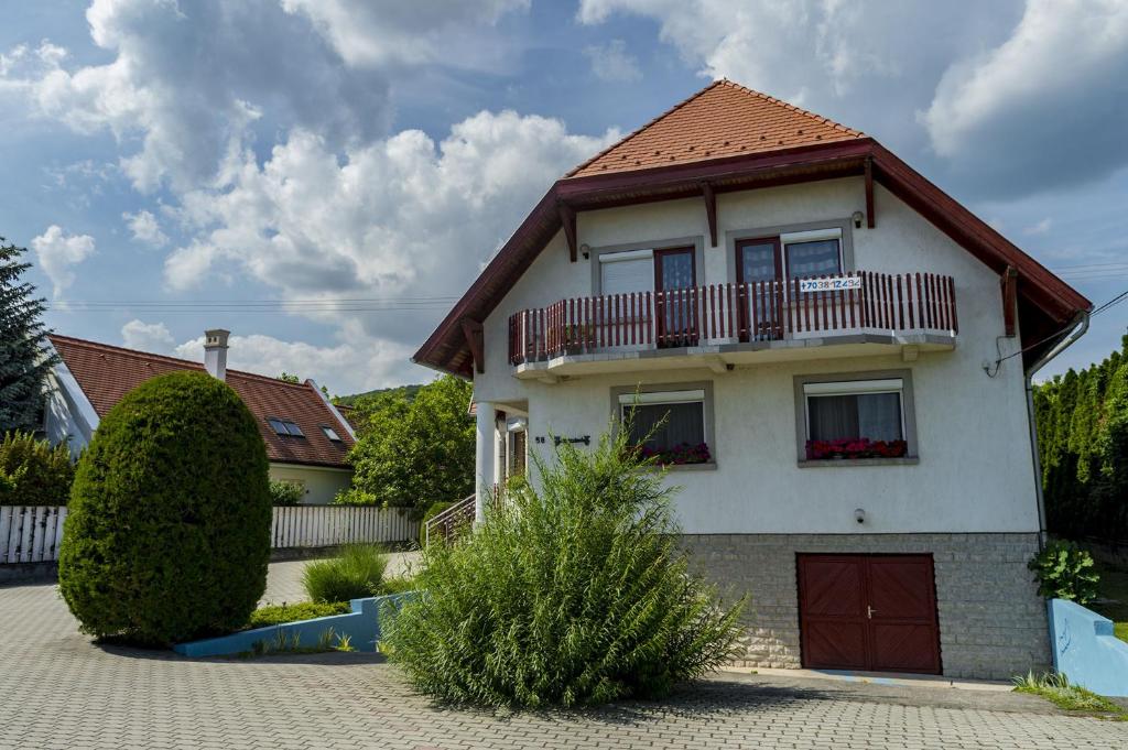 a white house with a red roof at Huszár Vendégház in Balatonfüred