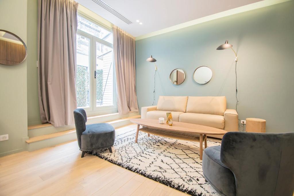 a living room with a couch and a table at Résidence du Marais - Paris Center in Paris