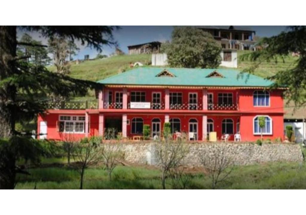 a large red house with a green roof at Valley View rooms near Khajjiar Lake in Lāhri