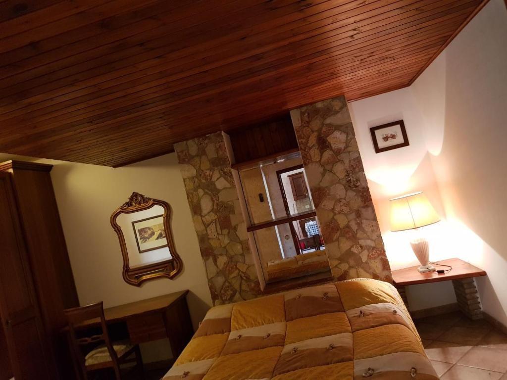 a bedroom with a bed and a wooden ceiling at Serenella Apartament in San Vito lo Capo