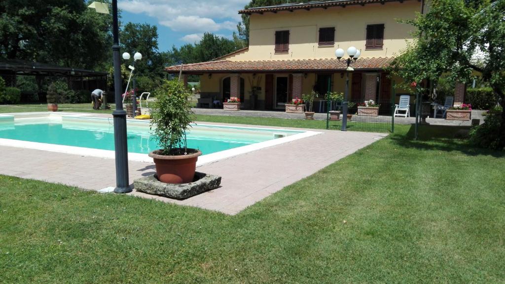 uma piscina com um vaso de plantas ao lado de uma casa em Colonica Poggio Renai em Castelfranco di Sopra