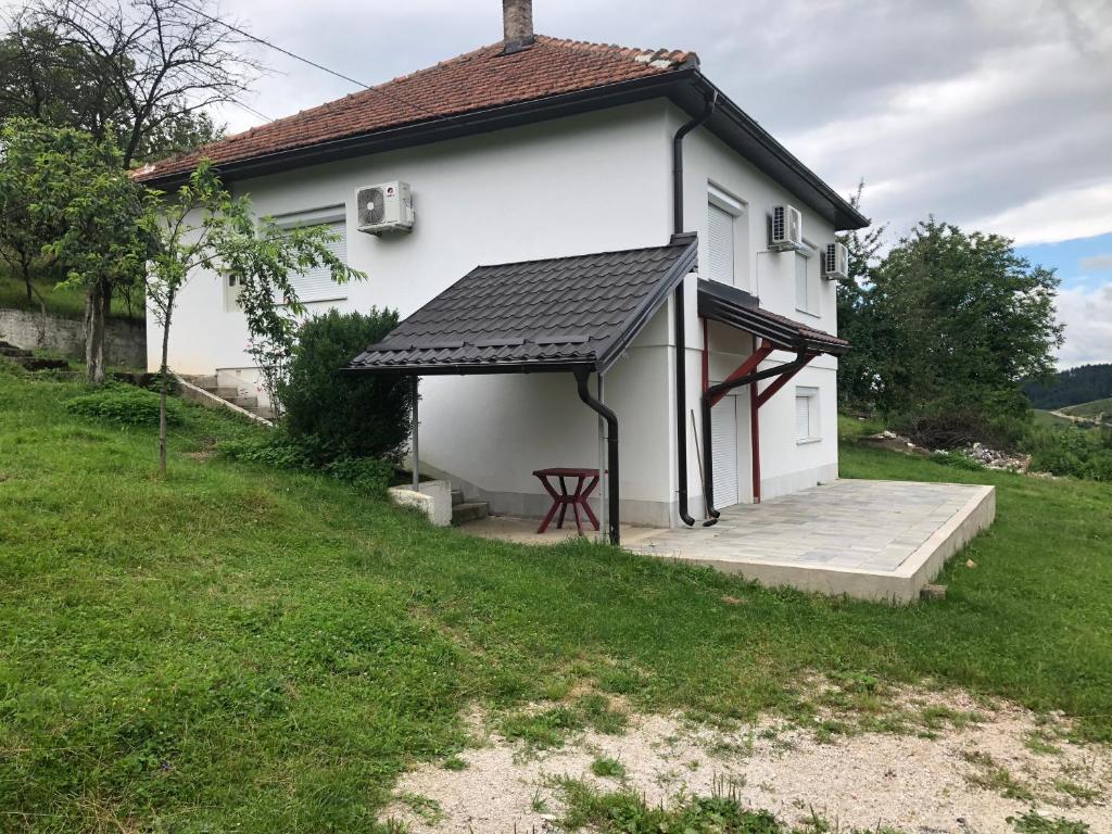 Casa blanca con porche y mesa de picnic en Villa Sultan en Sarajevo