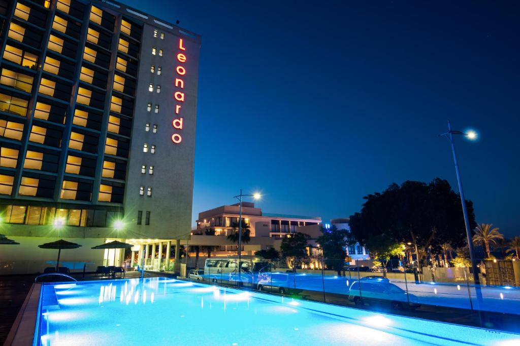 un hotel con piscina frente a un edificio en Leonardo Hotel Tiberias en Tiberias