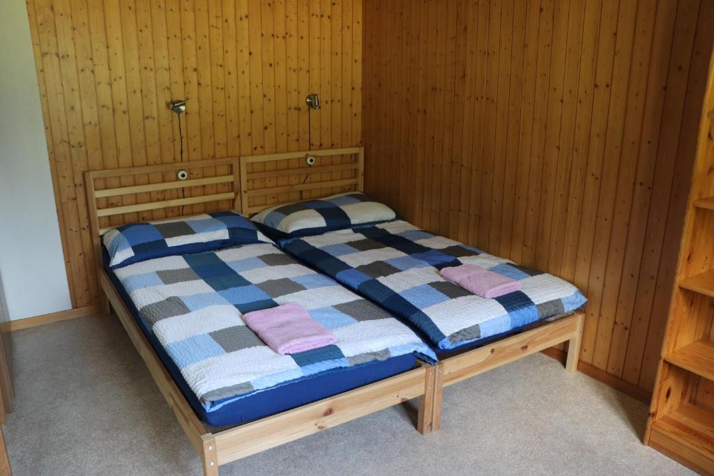 Bett in einem Zimmer mit Holzwänden in der Unterkunft Homestay Brienz in Brienz