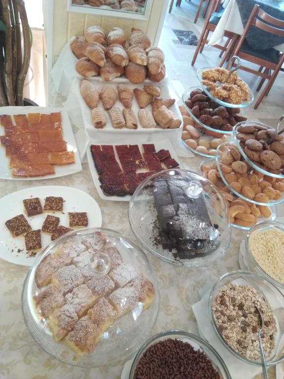 a table topped with lots of different types of pastries at Hotel Milanese in Rimini