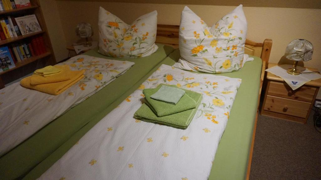 2 camas individuales en una habitación con toallas y almohadas en Gästezimmer Charlotte, en Dresden